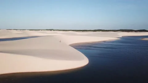 Guy walking alone in dunes of Lencois Maranhenses Stock-Footage 168403784