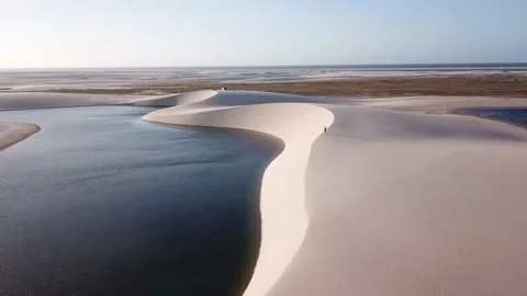 Guy walking alone in dunes of Lencois Maranhenses Video stock 168409435
