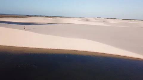 Guy walking alone in dunes of Lencois Maranhenses Video stock 168412619