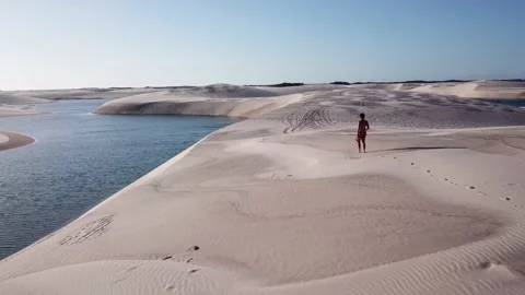 Guy walking alone in dunes of Lencois Maranhenses Video stock 168423296