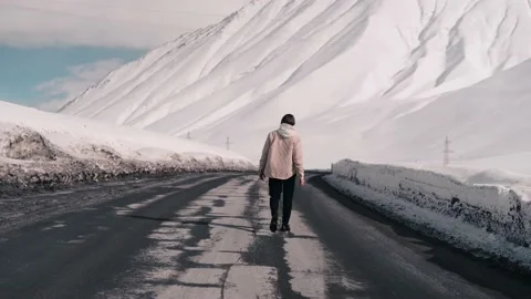 The guy is walking along the road in the mountains, spreading his arms Stock Footage 169813651