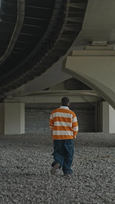 Guy Walking Away under City Bridge Back View Stock Footage 247165936