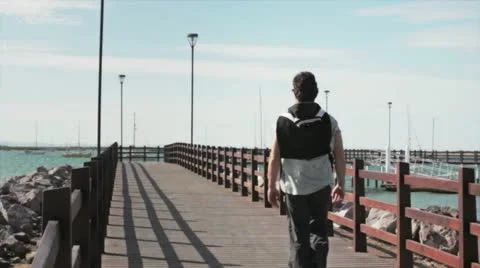 Guy walking on bridge Stock Footage 10846045