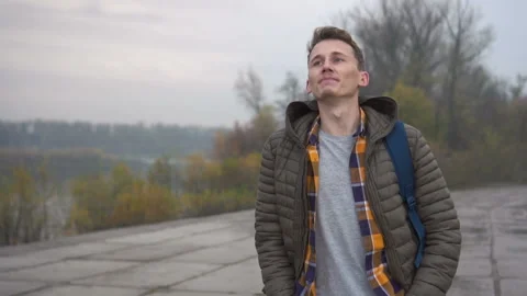 Guy walking in cloudy city . Handsome young caucasian man wearing casual jacket Stock Footage 100921111