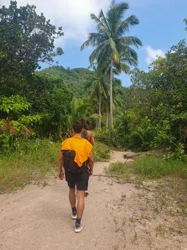 Guy walking on a dirt path with palm trees around in Koh Tao island, Thailand Stock Photos