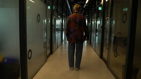 The guy is walking down the hall in the office Stock Footage 130877715