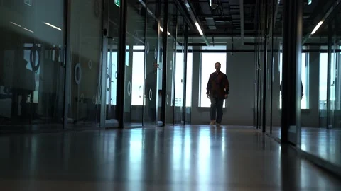 The guy is walking down the hall in the office Stock Footage 130877719