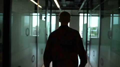 The guy is walking down the hall in the office Stock Footage 130877730