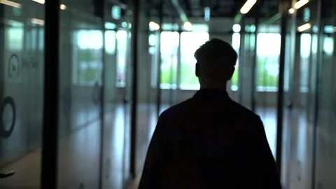 The guy is walking down the hall in the office Stock Footage 130877742