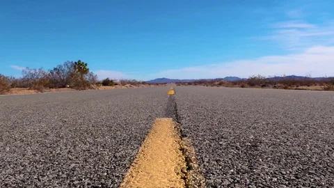 Guy walking in the middle of the desert road trying to find someone to Stock Footage 109476151
