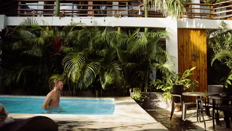 Guy walking out of a swimming pool, white male in swimmingshorts, exiting pool Stock Footage 318901022