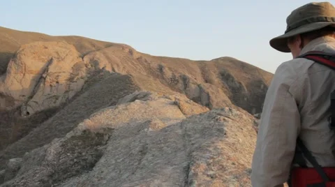 Guy walking on rocky terrain 스톡 동영상 61148598