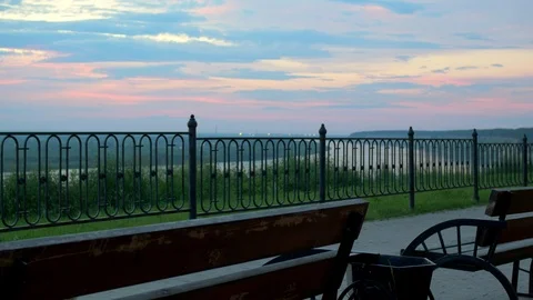 Guy walking on the sidewalk with a beautiful view of the river in a crimson Stock Footage 103872872