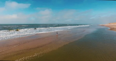 Guy walking through ocean aerial 4k Stock-Footage 153516803