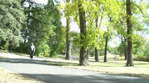 Guy Walking Through Park Stock Footage 12587652