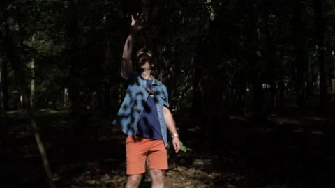 Guy is walking in the woods. Covers his face with his hand from the sun Stock Footage 140955330