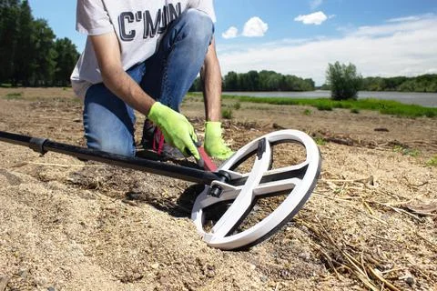 A guy walks along the beach looking for treasure with a wireless metal detect Stock Photos