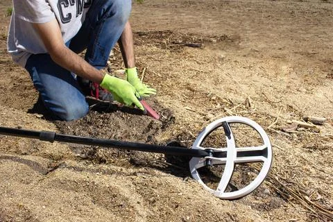 A guy walks along the beach looking for treasure with a wireless metal detect Stock Photos