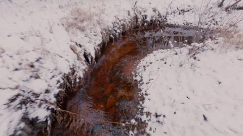 The guy walks along the bed of a narrow snow-covered river,overcoming obstacles. Stock Footage 321357823