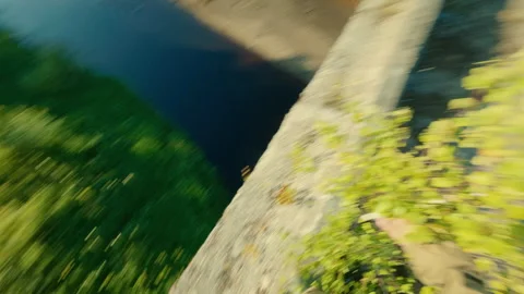 A guy walks along the edge of an old bridge without a guardrail. Risk to life. Stock Footage 313953208