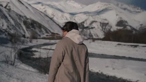 The guy walks along the mountain river in the mountains Stock Footage 169812346