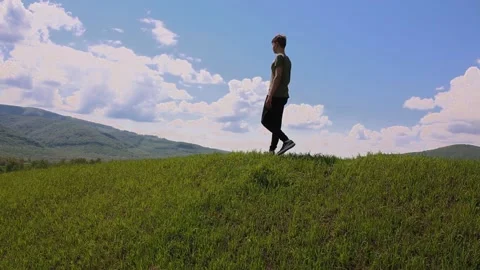 The guy walks along the top of the mountain and admires the scenery. Stock Footage 194460935