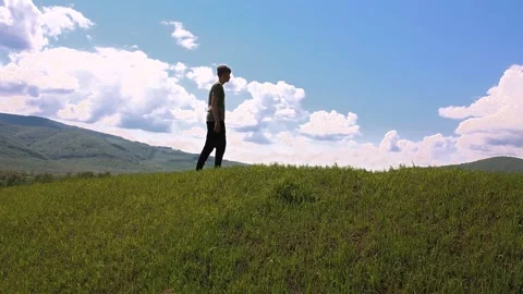 The guy walks along the top of the mountain and admires the scenery. Stock Footage 194511693