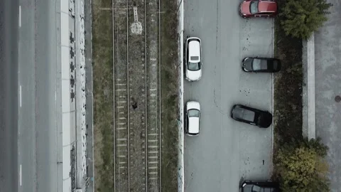 A guy walks along tram tracks in a bad neighborhood Stock Footage