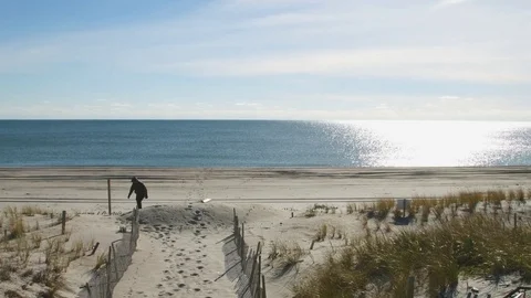 Guy walks into beautiful Ocean beach skyline Stock-Footage 75177780
