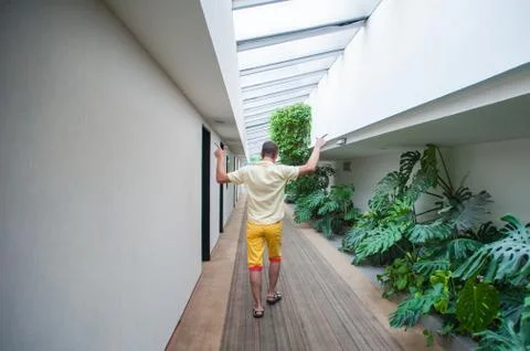 The guy walks down the hall with arms raised Foto stock