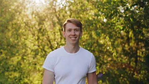 The guy walks in the evening smiling and looking at the camera Stock Footage 250484855