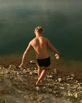 The guy walks into the lake. Foto stock