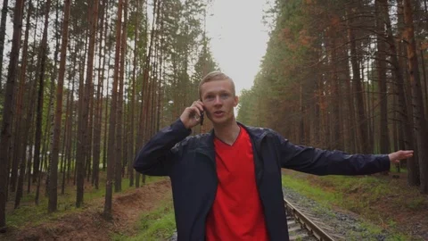 The guy walks on the rails and talks on the phone. Stock Footage 93975353