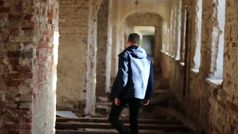 Guy walks through an abandoned building Stock Footage 130740165