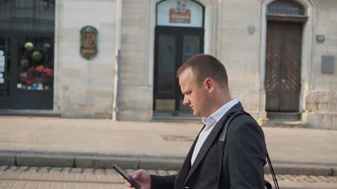 The guy walks through the ancient city and writes a message on a smartphone Stock Footage 160126740
