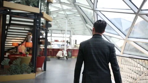 A guy walks through a shopping mall under a glass dome Stock Footage 128547612