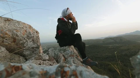 The guy walks on top of the mountain and eats an apple Stock Footage 112858160