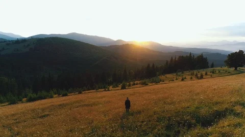 A guy walks in a valley of mountains Stock Footage 118619393