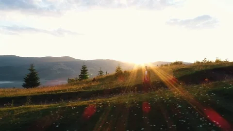The guy walks in the valley of mountains at sunset Stock Footage 118581888