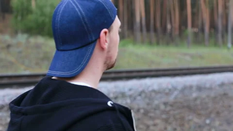 A guy walks in the woods along the train rails Stock Footage 90450980