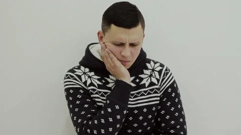 A guy in a warm sweater toothache Stock Footage 56433120