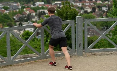 The guy warming up before training with a beautiful view of the city in Germany Stock Photos