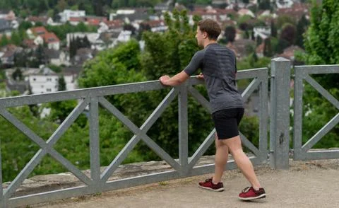 The guy warming up before training with a beautiful view of the city in Germany Stock Photos