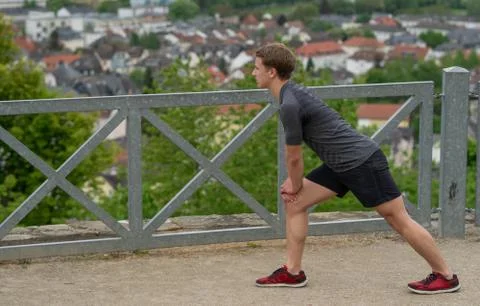 The guy warming up before training with a beautiful view of the city in Germany Stock Photos