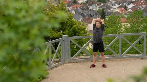 The guy warming up before training with a beautiful view of the city in Germany Stock Photos