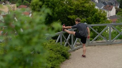 The guy warming up before training with a beautiful view of the city in Germany Stock Photos