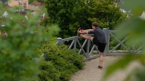 The guy warming up before training with a beautiful view of the city in Germany Stock Photos