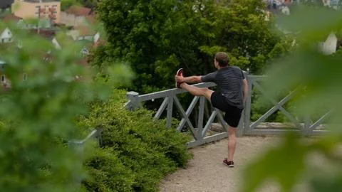 The guy warming up before training with a beautiful view of the city in Germany Stock Photos