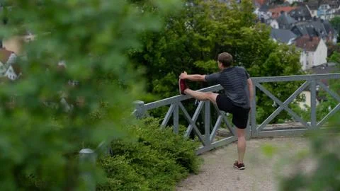 The guy warming up before training with a beautiful view of the city in Germany Stock Photos