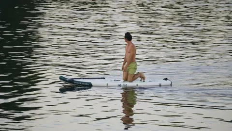 The guy was standing on his head on a swimming board and then got on his knees Stock Footage 204960551